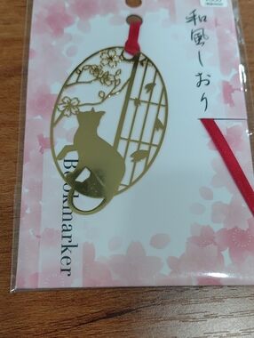 Source Unknown gold cat silhouette bookmark with red ribbon